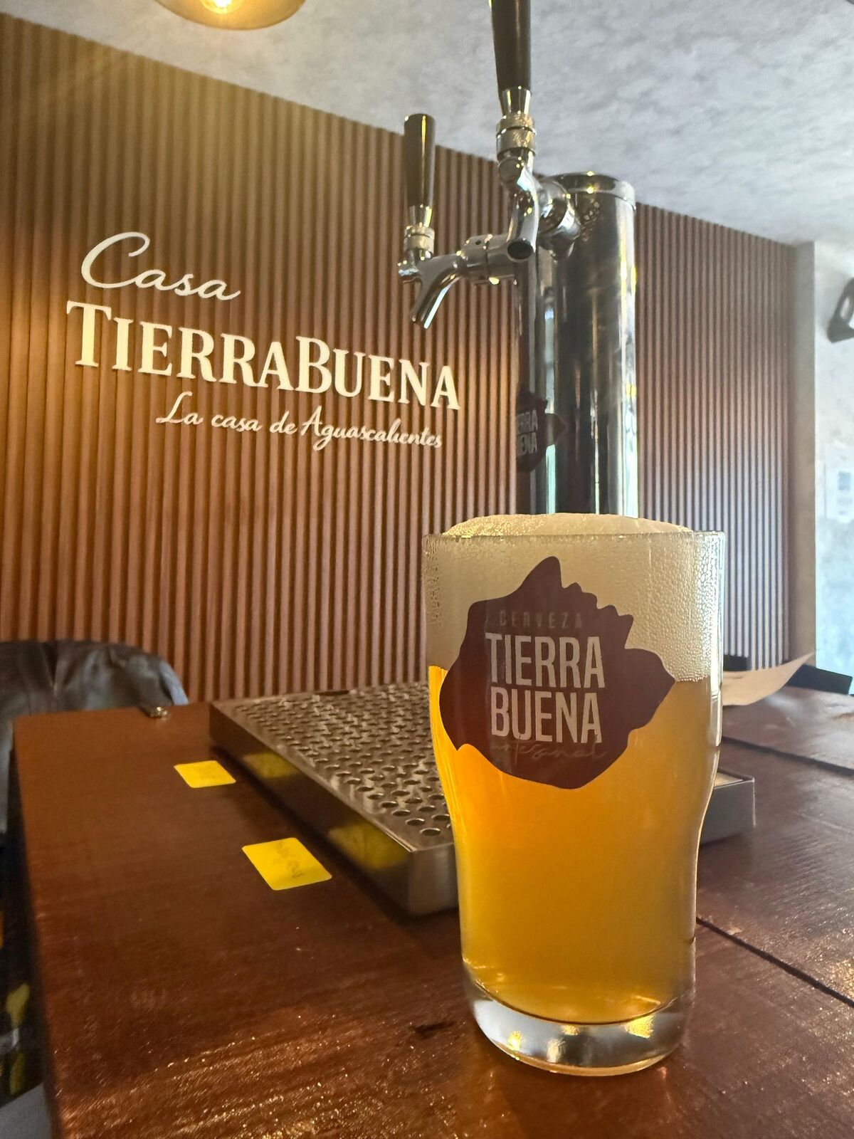 Vaso de cerveza artesanal TierraBuena servido en la barra de Casa TierraBuena, Aguascalientes