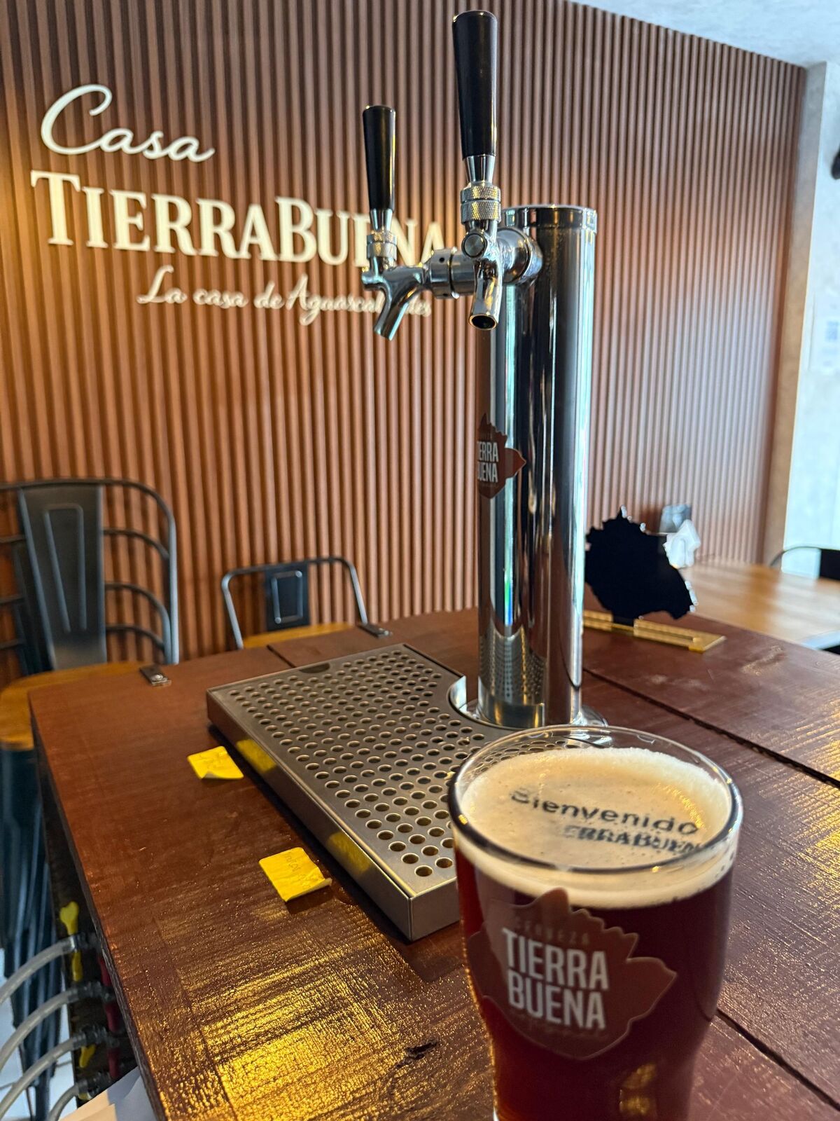 Cerveza oscura TierraBuena recién servida junto a las llaves de la barra